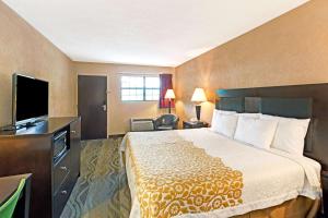 a hotel room with a bed and a flat screen tv at Days Inn by Wyndham Cherokee Near Casino in Cherokee