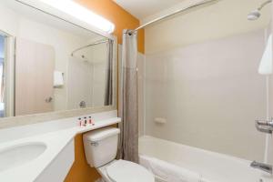 a bathroom with a toilet and a sink and a tub at Days Inn by Wyndham Florence Cincinnati Area in Florence