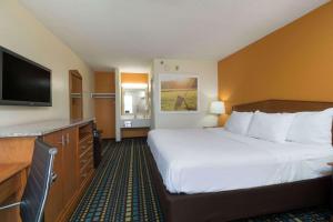 a hotel room with a large bed and a flat screen tv at Days Inn by Wyndham Florence Cincinnati Area in Florence