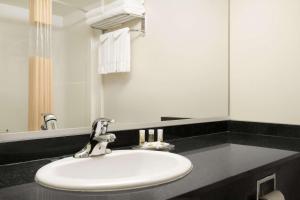 a bathroom with a white sink and a mirror at Days Inn & Suites by Wyndham Langley in Langley +35 photos