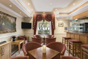 un restaurante con mesas y sillas y un bar en Days Inn Hyde Park, en Londres