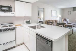 a kitchen with a sink and a stove top oven at The Grand Inn Peoria in Peoria