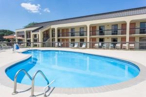 a large swimming pool in front of a hotel at Days Inn by Wyndham Norfolk Airport in Norfolk