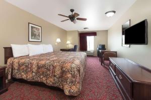 a hotel room with a bed and a flat screen tv at Days Inn by Wyndham St Peters/St Charles in Saint Peters