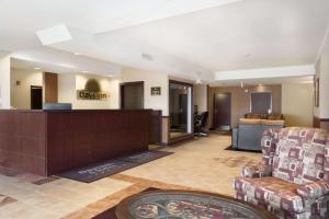 a hotel lobby with a reception desk and chairs at Days Inn & Suites by Wyndham Langley in Langley