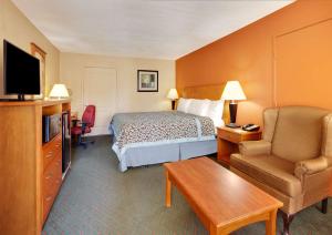 a hotel room with a bed and a chair at Days Inn by Wyndham Fairfield in Fairfield