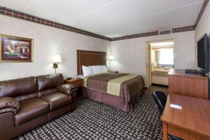 a hotel room with a bed and a couch at Days Inn by Wyndham Midland in Midland