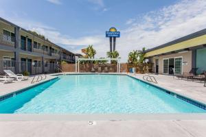 ein Swimmingpool in einem Hotel mit Hotelschild in der Unterkunft Days Inn by Wyndham San Diego-East/El Cajon in El Cajon