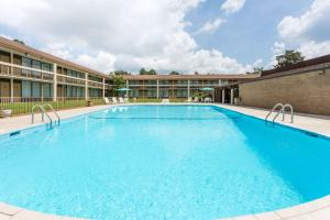 una gran piscina frente a un edificio en Days Inn & Conf Center by Wyndham Southern Pines Pinehurst, en Southern Pines