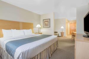 a hotel room with a large bed and a flat screen tv at Days Inn by Wyndham Chino Valley in Chino Valley