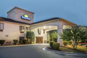 un hotel con un cartel en la parte delantera en Days Inn by Wyndham Burlington East, en Haw River