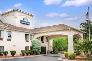 a hotel with a sign on top of a building at Days Inn by Wyndham Burlington East in Haw River