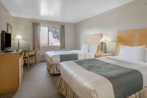 a hotel room with two beds and a television at Days Inn by Wyndham Chino Valley in Chino Valley