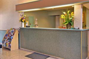 a lobby with a counter with flowers on it at Mission Inn and Suites in Hayward