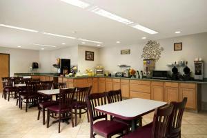 a restaurant with tables and chairs and a kitchen at Colony Inn in Kent