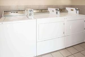 two washers and a dryer in a room at Days Inn by Wyndham N.W. Medical Center in San Antonio