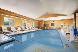 a large swimming pool with chairs and tables at Days Inn & Suites by Wyndham Cedar Rapids in Cedar Rapids