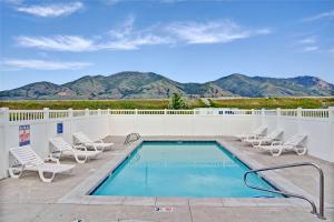a swimming pool with chaise lounge chairs and a pool at Days Inn by Wyndham Brigham City in Brigham City
