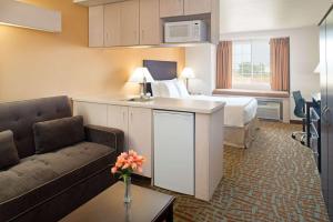 a hotel room with a bed and a couch at Days Inn & Suites by Wyndham Spokane Airport Airway Heights in Airway Heights