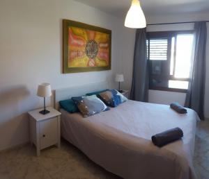 a bedroom with a large white bed with blue pillows at El Hierro in El Médano