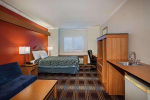 a hotel room with a bed and a sink at Days Inn & Suites by Wyndham Antioch in Antioch