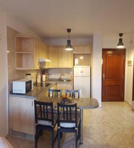 een keuken met een tafel en stoelen en een koelkast bij El Hierro in El Médano