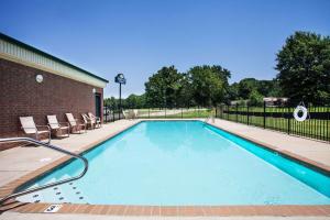 a large swimming pool with chairs and a building at Days Inn & Suites by Wyndham Wynne in Wynne