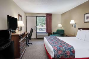 een hotelkamer met een bed en een flatscreen-tv bij Days Inn by Wyndham Hoover Birmingham in Hoover