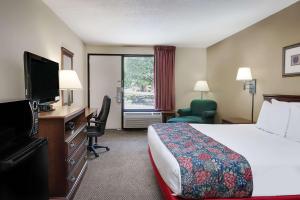 a hotel room with a bed and a flat screen tv at Days Inn by Wyndham Hoover Birmingham in Hoover