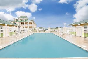 a pool at a resort with chairs and a building at Days Inn by Wyndham Trumann AR in Trumann