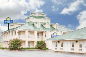 a large white building with a green roof at Days Inn by Wyndham Trumann AR in Trumann