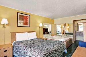 Days Inn by Wyndham Knoxville West في نوكسفيل: غرفة في الفندق مع سرير وحوض استحمام