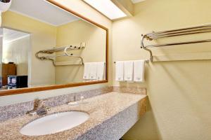 y baño con lavabo y espejo. en Days Inn by Wyndham Knoxville West en Knoxville