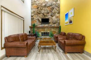 a living room with two couches and a stone fireplace at Days Inn by Wyndham Delta in Delta