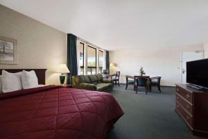 ein Hotelzimmer mit einem Bett und einem Wohnzimmer in der Unterkunft Days Inn by Wyndham Gilroy in Gilroy