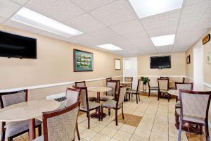 a dining room with tables and chairs and a flat screen tv at Days Inn by Wyndham Knoxville West in Knoxville