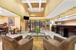 a lobby at a hospital with couches and a table at Days Inn & Suites by Wyndham DeSoto in DeSoto