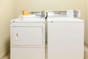 a white refrigerator and a washing machine in a room at Lone Star Inn & Suites in Groesbeck
