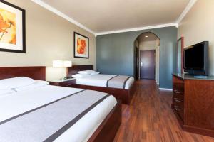 a hotel room with two beds and a flat screen tv at Lone Star Inn & Suites in Groesbeck