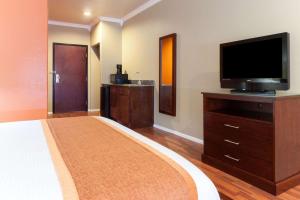 a living room with a television and a large room at Lone Star Inn & Suites in Groesbeck