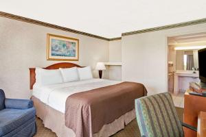 A bed or beds in a room at Days Inn by Wyndham Forrest City