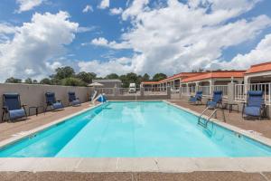 a large swimming pool with chairs at Days Inn by Wyndham Pearl/Jackson Airport in Pearl