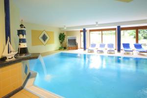 a large swimming pool with blue chairs and a lighthouse at Landhotel Salmen in Oberkirch