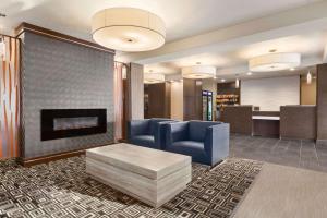 a lobby with a blue couch and a fireplace at Days Inn & Suites by Wyndham Yorkton in Yorkton