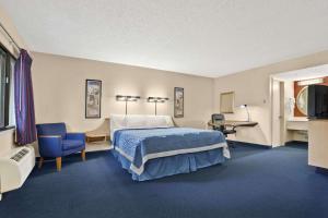 a large hotel room with a bed and a desk at Days Inn by Wyndham Buena Park in Buena Park