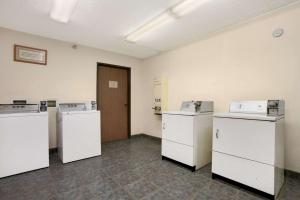 a room with three washers and refrigerators in it at Days Inn by Wyndham Buena Park in Buena Park