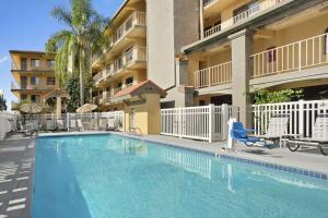 a swimming pool in front of a apartment building at Days Inn by Wyndham Buena Park in Buena Park