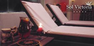 a candle sitting on a table next to two chairs at Sol Victoria Hotel SPA & Casino in Victoria