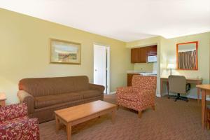 uma sala de estar com um sofá, cadeiras e uma mesa em Days Inn by Wyndham St. Louis/Westport MO em Maryland Heights