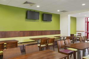 a restaurant with tables and chairs in it at Days Inn Magor in Magor